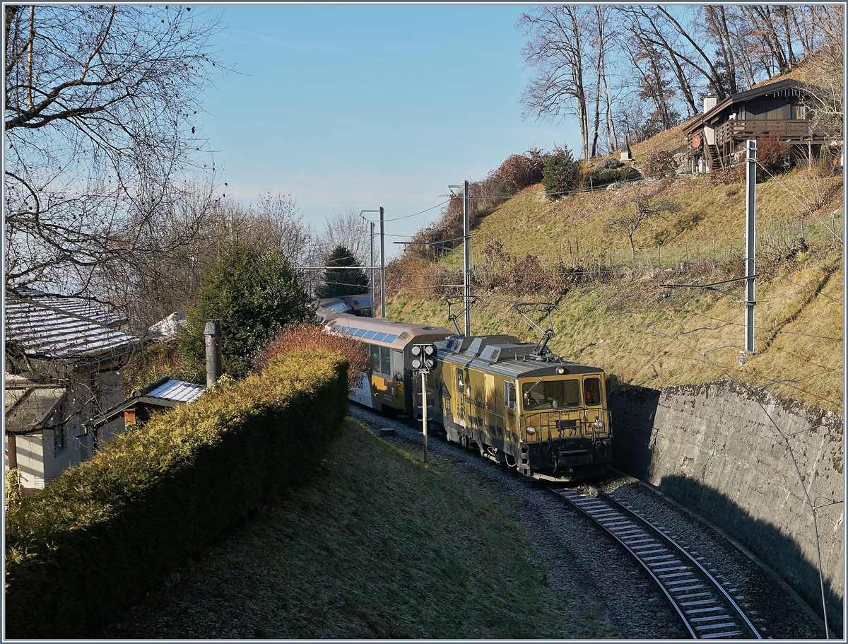 Bei Sonzier beschreibt die Bah eine 180 Grade Wende, trotz des engen Radius musste die Anfahrt durch Stützmaueren abgesichert etwas in den Berghang hineingebaut werden. Das Bild zeigt eine MOB GDe 4/4 mit ihrem Panoramic Express bei der Einfahrt in die Wendeschleife. 
28. Dez. 2016