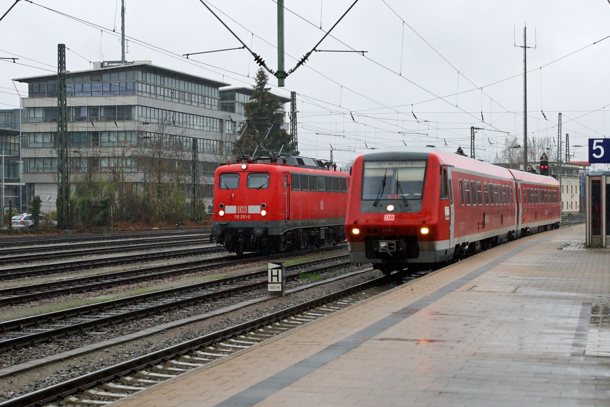 DB: Fotografieren in Singen am 20. November 2015 trotz starkem Wind und Dauerregen. Begegnung zwischen der 115 261-0 und dem Zug nach Ulm mit BR 611 in Singen.
Foto: Walter Ruetsch 