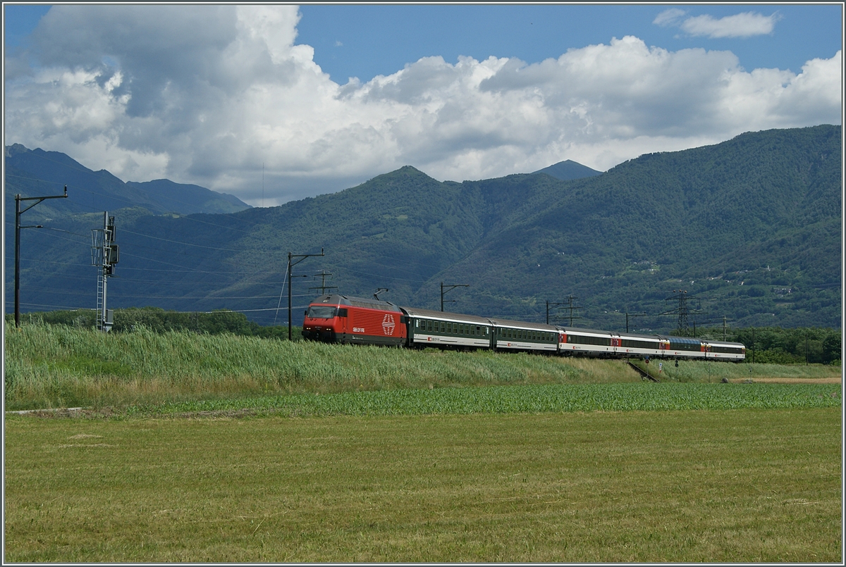 Eine RE 460 ist mit ihrem  Gotthard -IR kurz vor Riazzino schon fast am Ziel ihrer Fahrt. 
Zur Zeit wird (Herbst 2019) die Strecke nun auf zwei Gleise ausgebaut.

Die Aufnahme entstand am 21. Juni 2015