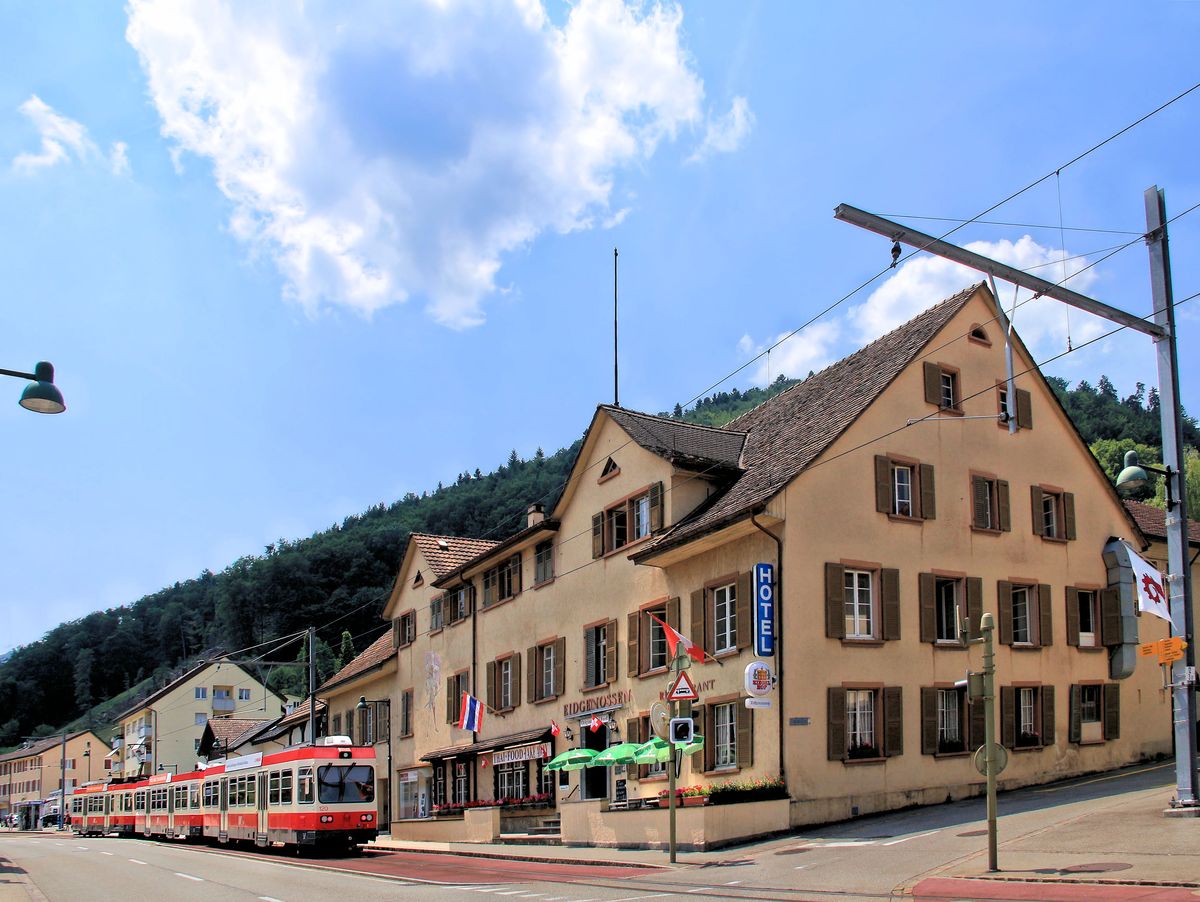 Entlang der Pass-Strasse trifft man auch auf das Hotel  Eidgenosse  in Oberdorf, wo man sich - heute ganz natürlich und so wunderbar im Einklang mit dem Hotelnamen - thailändisch verpflegen kann. Davor schaukelt ein Dreiwagenzug mit Steuerwagen 120 und 116 und Triebwagen 16 an der Spitze die recht steile Strasse hinauf. 22.Juni 2017 