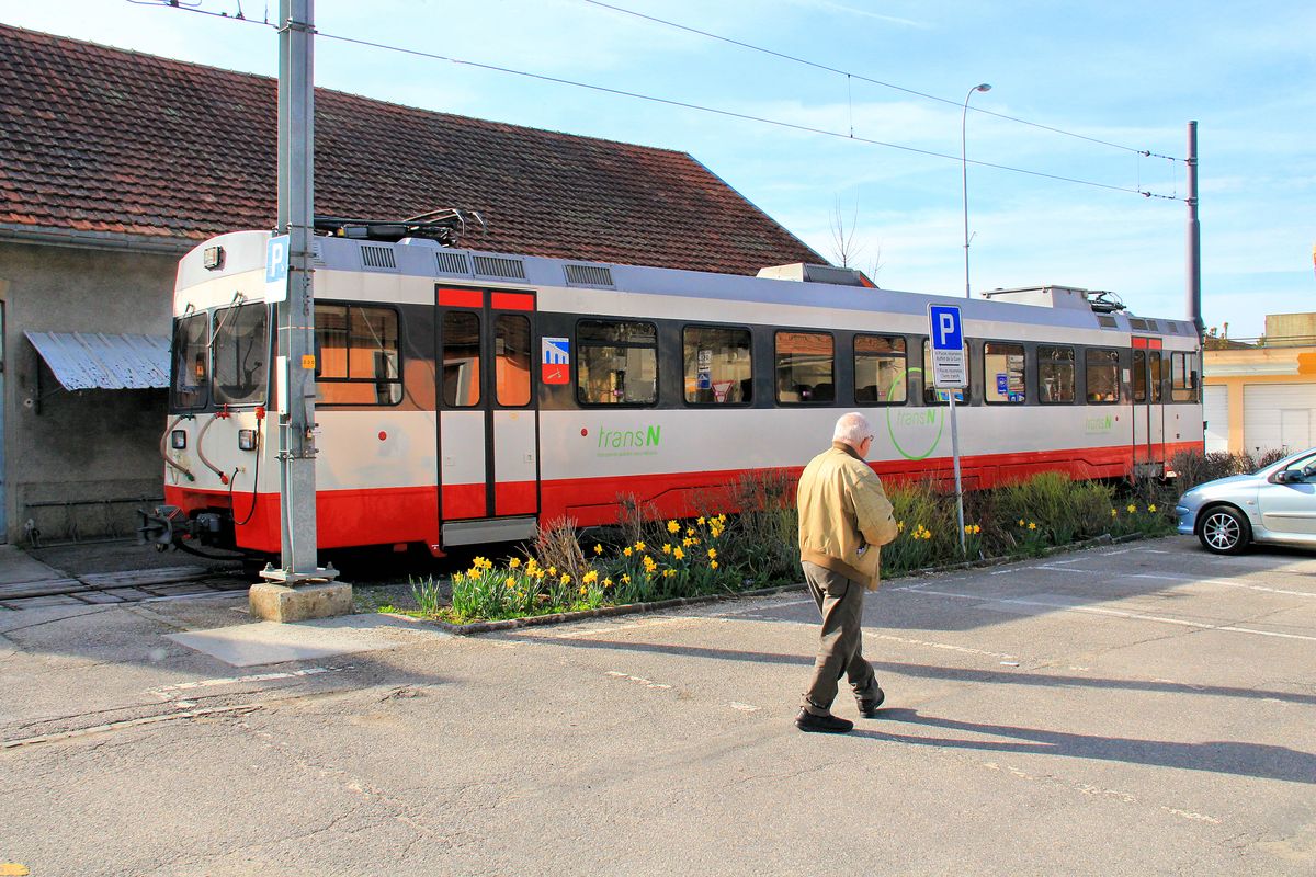 Friedliche Mittagszeit - ein Mann wandert über den Platz, gelbe Blumen blühen und Triebwagen 7 döst vor sich hin. Les-Ponts-de-Martel, 21.April 2016. 
