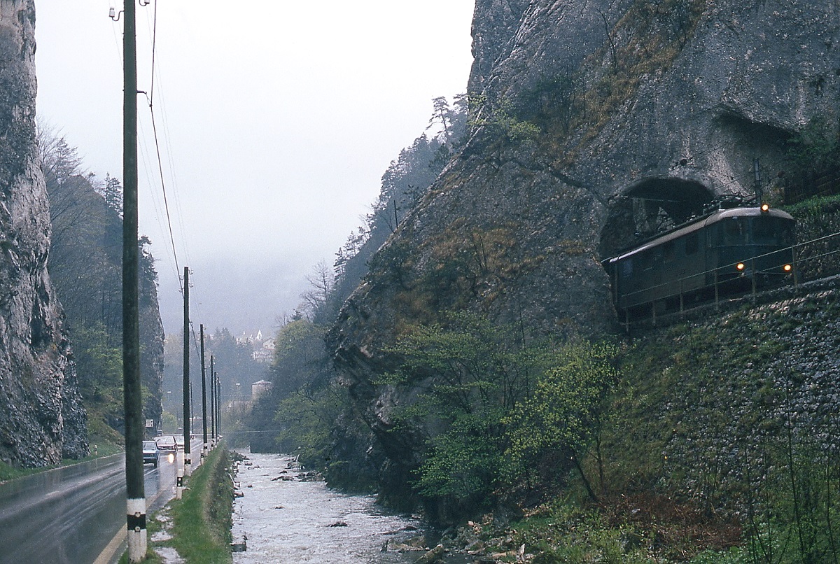 Viel enger als an dieser Stelle in der Klus zwischen Choindez und Moutier geht es wohl kaum. Bei str�menden Regen, von dem die Passagiere sicherlich weniger sp�rten als der Fotograf, f�hrt dort eine Re 4/4 I im Juli 1983 nach Moutier.