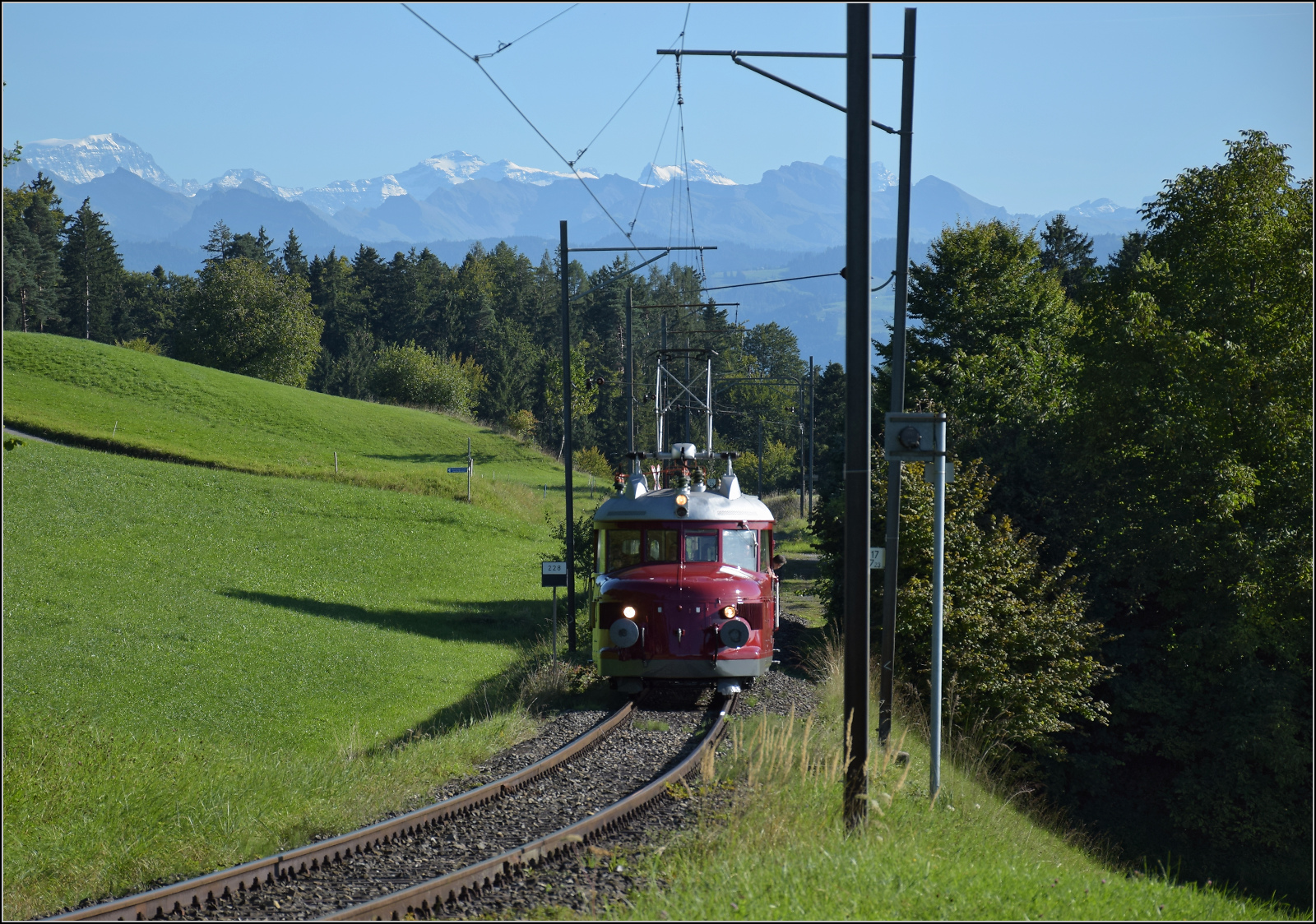150 Jahre Tösstalbahn.

Der Rote Pfeil aus Balsthal durfte beim Jubiläum mitfeiern. Nach dem Aussendienst auf der Kempttalbahn ging es für RCe 2/4 607 zur Übernachtung nach Bauma. Hier nahe des Haltepunks Ettenhausen-Emmetschloo. Im Hintergrund sind Tödi (3613 m), Clariden (3267 m) und der Chammliberg (3215 m) prominent im Bild. September 2025.