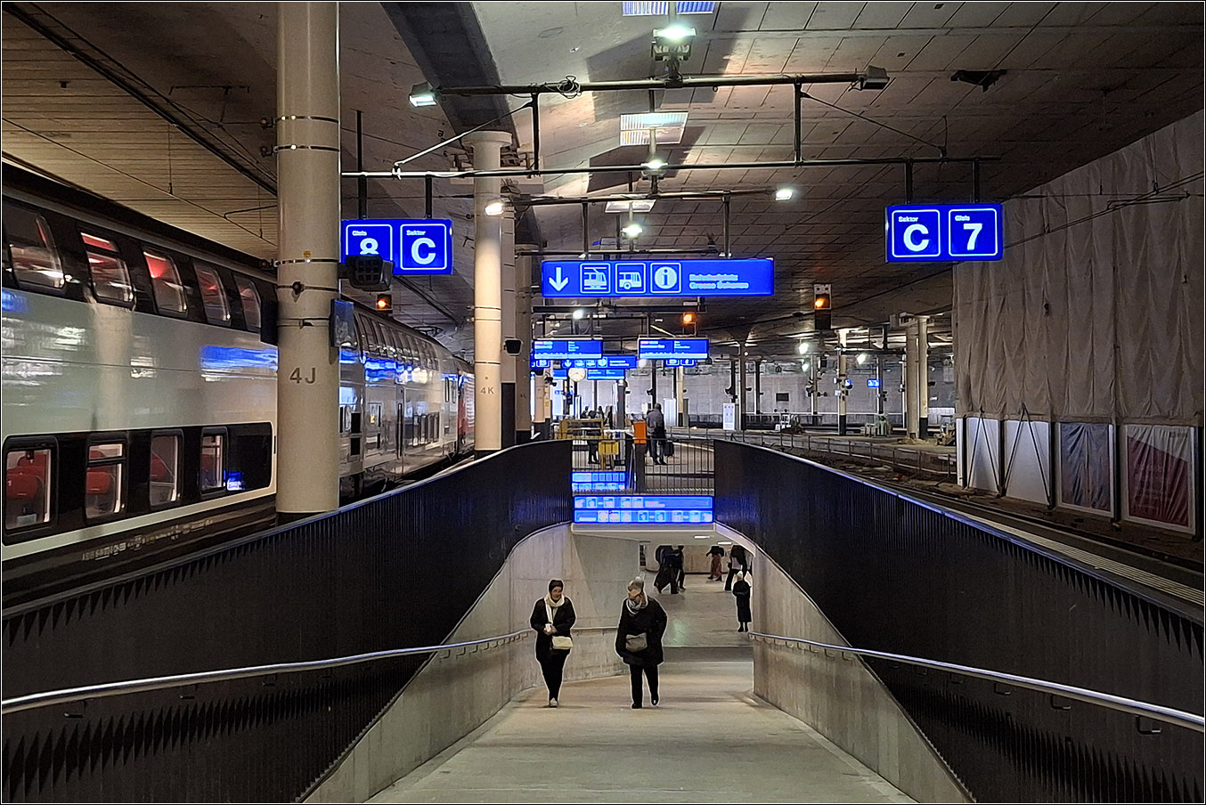 Der Bahnhof Bern - 

Ein Großteil der Bahnsteige sind durch ein Parkdeck überbaut, daher hat der Bahnhof einen weitgehenden unterirdische Charakter. Die Bauzeit des Bahnhofes mit abschnittsweiser Inbetriebnahme dauerte 17 Jahre, damit vielleicht etwas länger als Stuttgart 21.

Rampen und auf der anderen Seite feste Treppen führen von der Bahnsteigunterführung hinauf zu den Bahnsteigen. Ein zweite großzügiger Unterführung entsteht weiter westlich im Zusammenhang mit dem Neubau des großen unterirdischen Bahnhofes für die RBS.

05.03.2025