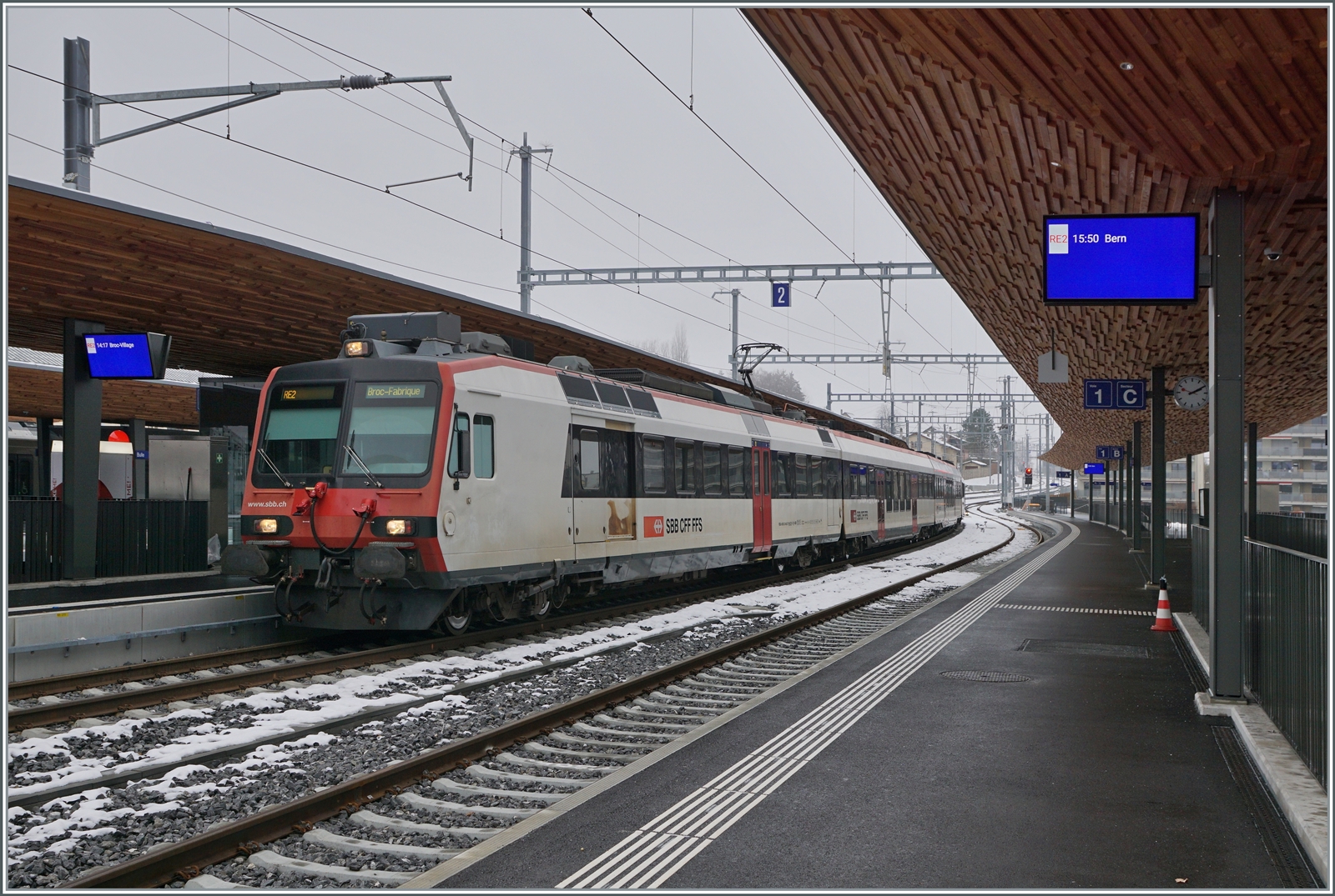 Ein SBB RBDe 560 wartet in Bulle auf die Abfahrt nach Broc. Beachtenswert die eindrücklche Bahnstigdachunterseite! 
Und - fährt der Zug nach Broc FABRIQUE (wie auf dem Zug vermerkt) oder nach Broc VILLAGE (wie auf dem Bahnsteig angekündigt? 
Die Antwort ist auf dem folgenden Bild zu sehen...

15. Dezember 2022