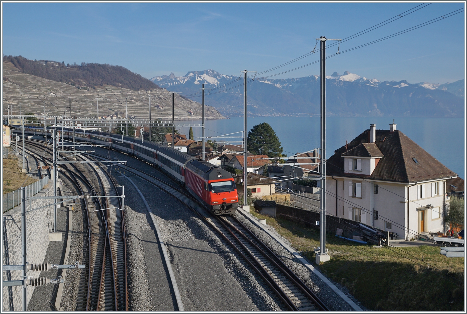 Eine SBB Re 460 ist in Cully mit einem IR90 in Richtung Genève Aéroport unterwegs.

16. Feb. 2023