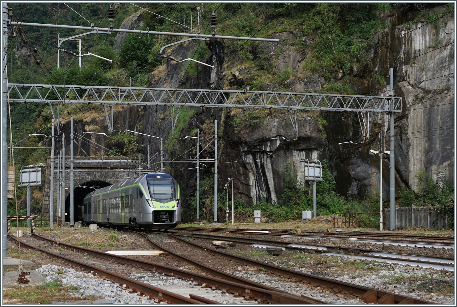 Hinter diesem Bild des aus dem Iselle Tunnel in den Bahnhof von Iselle einfahrenden Zuges verbirgt sich ein ungwöhnlichr Zuglauf: Der BLS RE 11 4545 ist von Biel/Bienne (ab 07:34) nach Iselle di Trasquera (an 09:58) unterwegs. Der Zug bediente Lyss, Zollikofen, Ostermundigen, Gümligen, Münsingen, Thun, Spiez, Mülenen, Reichenbach im Kandertal, Frutigen, Kandersteg, Goppenstein, Hohtenn, Ausserberg, Eggerberg und Brig; fuhr demnach also nicht via Bern.
Der Zug besteht aus dem BLS RABe 528 111 und 101. Für die Weiterfahrt infolge Baurabeiten stehen etliche Buse zur Verfügung. 
Die Eigentumsgrenze zwischen der FS und SBB liegt im hier zu sehenden 169 Meter langen Iselle Tunnel, welcher auf 144 Meter länge der SBB gehört.

17. August 2024