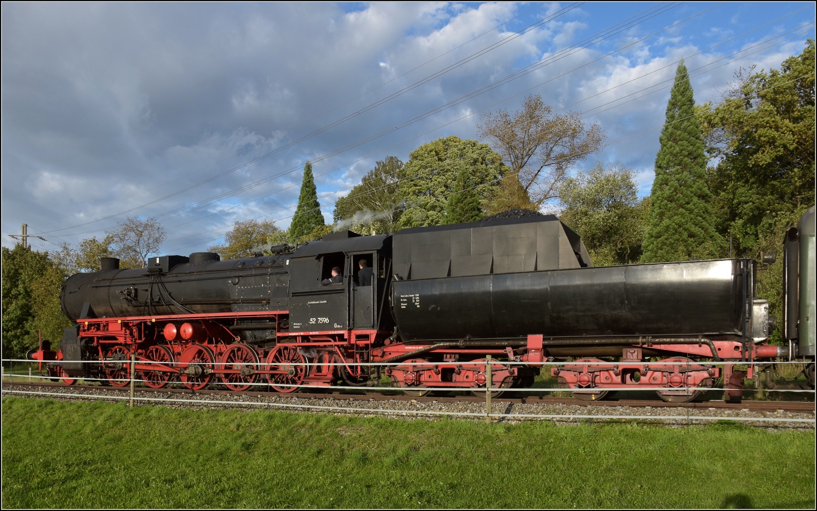Schienenverkehr am Schienerberg. 

52 7596 mit ihrem EFZ-Sonderzug für die SEHR&RS zwischen Hemishofen und Ramsen auf der letzten Fahrt des Tages. Oktober 2022.