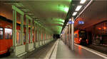 Der Bahnhof Bern - 

Der Tunnelbahnhof der RBS mit einem abfahrenden RE5 nach Solothurn. Die Stützen zwischen den beiden mittleren Gleisen wurde nachträglich eingebaut, vermutlich im Zusammenhang mit dem Neubau des RBS Bahnhofes in großer Tieflage, dessen vier neue Tunnelröhren unter dem alten RBS-Bahnhof hindurchführen.

Der ansich schlichte unterirdische Bahnhof wird durch die Beleuchtung in Grün und Orange deutlich aufgewertet.

07.03.2025