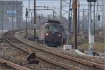 Zwei Re 425 der BLS bringen aus Muttenz ihren Güterzug die Steigung Richtung Pratteln hoch.
