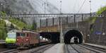 Am 07.05.2024 warten die Re 465 002 und Re 425 192 im Bahnhof Goppenstein vor ihren Autozügen auf die Abfahrt durch den Lötschbergtunnel nach Kandersteg, rechts im Tunnel nähert sich