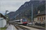 Blick auf die kleine Station Champ-du-Moulin und einen in Richtung Neuchâtel ausfahrenden Regionalzug.