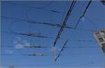 Abschied von einem Unikum, der Mehrsystemoberleitung in Z�rich Giessh�bel.

Hier in Giessh�bel treffen Gleichstrom und Wechselstrom aufeinander. So weicht die 1,2 kV Gleichstromfahrleitung der Uetlibergbahn seitlich aus. Kompliziert wird es an den Weichen, so ist hier jeweils oben die Gleichstromleitung und darunter die 15 kV Wechselstromleitung. Im Weichenbereich muss nat�rlich stromlos gefahren werden. April 2022.