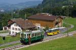 BC/LJB: Der Ce 2/2 12, 1907 (ex OJB/LJB) der Museumsbahn Blonay Chamby anl�sslich einer Begegnung mit einem Postauto der Marke SAURER bei Cornaux-Chamby am 8.
