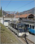 Die MOB GDe 4/4 wartet auf einem Abstellgleis in Zweisimmen mit offener Tür und einem unvorteilhaften Schattenwurf auf den Einsatz vor dem MOB Goldenpass Panoramic Express 2123.