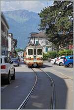 Der letzte noch in der braunen Farbgebung gehaltene AL Zug, bestehend aus dem AL Bt 351  Aigle  und dem AL BDeh 4/4 302  Leysin  ist in der Altstadt von Aigle auf der Fahrt zum Bahnhof von Aigle.