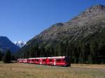 Die schneebedeckten Berge der Bernina-Gruppe und der talwärtsfahrende R 1632 von Tirano nach St.